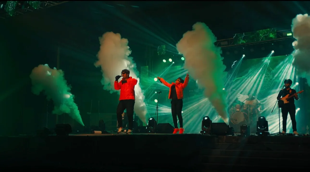 Urumi's full stage lit between rising columns of smoke